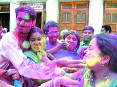 Residents apply gulal on one another to celebrate Holi at Durgiana Temple in Amritsar on Friday. 