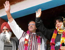 Peoples Democratic Party president Mehbooba Mufti and finance minister Tariq Hamid Karra wave to supporters during a party rally at Natipora district in Srinagar on Friday.