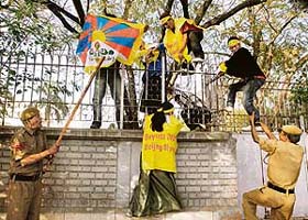 Tibetans jump inside the Chinese Embassy as police personnel try to stop them in New Delhi