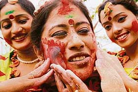 Women apply coloured powder on each other during Holi celebrations in Siliguri