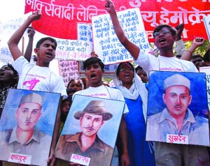 Activists of CPI(ML) hold posters of Shaheed Bhagat Singh, Rajguru and Sukhdev on the occasion of the 78th martyrdom day of the freedom fighters, at Jantar Mantar in the Capital on Sunday. 