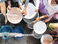 With water supply being hit due to a breach in a channel, people fill up buckets from a water tank in Gurgaon on Sunday.