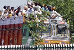 People atop a truck unmindful of their safety as they return from Hola Mohalla celebrations on Sunday.