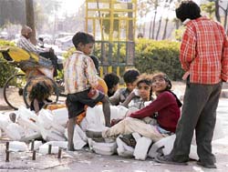 POORLY CONNECTED: Street children make do with mobile phones made from a packaging material in Ludhiana on Sunday.