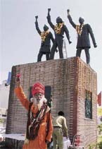 A nihang raises a slogan of patriotism near the statues of Bhagat Singh, Rajguru and Sukhdev on their martyrdom day in Ludhiana on Sunday.