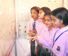 Schoolchildren crowd around the exhibits at a philately show organised in Rohtak recently.