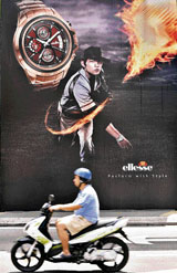 A man rides past an advertisement in downtown Kuala Lumpur on Monday.