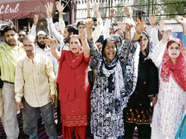 People protest outside the regional passport office in support of their demands in Jammu on Monday.