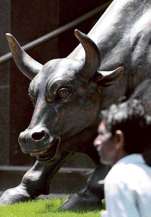 A man walks past a statue of a bull outside the Mumbai Stock Exchange building in Mumbai on Tuesday. Share prices rose by 4.02 per cent after a Wall Street rally sparked by a surprise rebound in existing home sales in the US. The 30-share benchmark Mumbai stock exchange Sensex index rose by 615.18 points to a days high of 15,904.58, its fourth straight day of gains. 