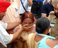 Police personnel in civil clothes gags a woman