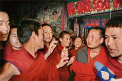 Tibetan Buddhist monks speak to foreign journalists at Jokhang temple in Lhasa on Thursday. Underlining the tension, a group of monks at the city's Jokhang temple staged a brief protest in the presence of the reporters, shouting down a Chinese official who was briefing the journalists on the unrest.  AFP photo