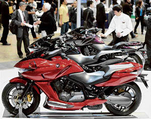 A cleaner cleans a new 680cc Honda motorcycle "DN-01" at the Tokyo Motorcycle Show in Tokyo on Friday. Honda put the product equipped with its new automatic transmission system on the market this month.