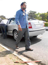 One of the injured walks past a car after he was attacked by students at Panjab University, Chandigarh, on Friday.