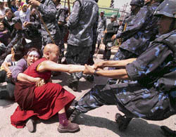 Policemen try to detain a Tibetan activist outside the visa section of the Chinese embassy in Kathmandu on Saturday.
