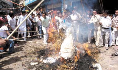 BJP activists burn the effigy of Chief Minister Sheila Dikshit during a demonstration against the price rise of essential commodities at Pahargang in the Capital