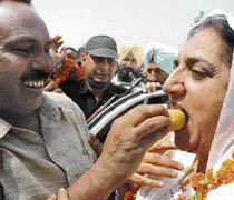 A Congress leader offers a laddoo to Rajinder Kaur Bhattal, president, Punjab Pradesh Congress Committee, at Rajpura on Sunday.