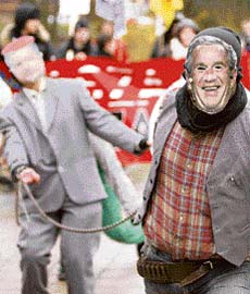 Protesters wearing masks of US President George W. Bush (right) and Polish President Lech Kaczynski march through Slupsk, northern Poland