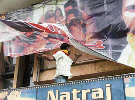 A member of the Kannnada Rakshana Vedike tears poster of a Tamil movie in Bangalore on Wednesday.