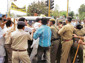 Activists of the Haryana Janhit Congress scuffle with policemen in a bid to prevent them from taking away effigies they planned to burn during a demonstration against rising prices in Hisar on Thursday.