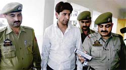 Deepak Dogra, alias Minta Langra, accused in the double murder case in Shimla being taken away by the police in Jammu on Thursday. 