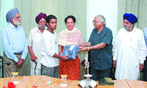 A student gets a prize from college governing council chief Balbir Kaur in Jalandhar. 