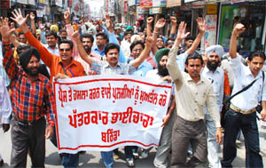 Media persons wearing black badges, raising slogans to protest against the police misbehaviour, in Bathinda on Friday.