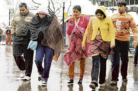 A family caught in the rain in Shimla on Saturday.