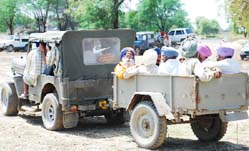 Necessity is the mother of invention: People travelling in a trailer attached to a jeep while going for a meeting near Kot Shamir village in Bathinda
