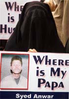 An activist from the All-Party Hurriyat Conference holds placard and photograph during a protest in Srinagar on Monday.
