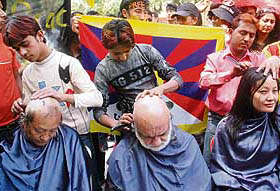 Tibetan protesters get their heads shaved in New Delhi on Monday to protest against the situation in Tibet.