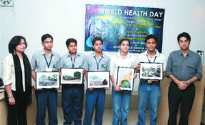 Students of Spring Dale School display pictures of various garbage sites in the city on World Health Day