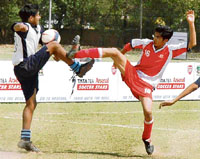 The players of St Kabir and Saupins School struggle to take control of the ball during the Inter-school soccer meet held at Football ground in Sector 17, Chandigarh, on Tuesday.