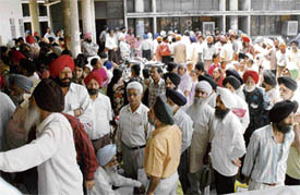 Riot victims wait outside Bachat Bhawan in Ludhiana on Tuesday.