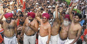 Brick-kiln workers with their shirts removed in protest against rising inflation in Ludhiana on Tuesday.