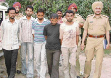 Members of a gang of robbers being taken to the district courts in Ludhiana on Thursday.