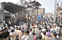 The Pakistani police and residents gather after an explosion at a scrap market in Lahore