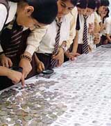Schoolchildren watch the collection of coins at the RBI exhibition in Chandigarh on Saturday.