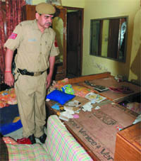 A Delhi Police official inspects a house which was robbed in the Adarsh Nagar area of the Capital on Saturday.