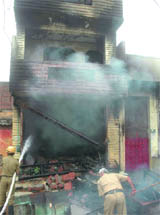 Firemen try to douse flames at a shop in the Kingsway Camp area in the Capital on Saturday.