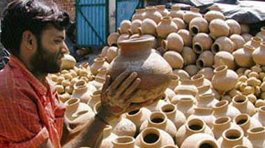 With the rise in temperature, a potter tries to meet the demand for earthen pots. 
