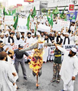 Activists of Pakistani Jamaat Ahle Sunnat torch an effigy of Danish cartoonist in Karachi