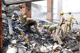 Firemen clear debris from the store of a scrap dealer that got burnt at Majhog village in Hamirpur district on Tuesday night.