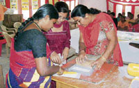 Habeeba Beebi (left) of C-DOT, Madurai, gives training to motivators in making sanitary napkins.