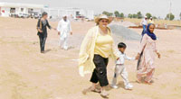 Margaret Margrave, a trustee of the Buwan Kothi International Trust, takes a child to the newly set up Gilly Mundy Community School in Leherian in Fatehabad.