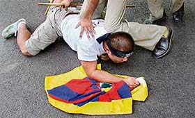 Policemen detain a Tibetan near India Gate