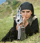 A woman village defence committee member holds a gun in her fight against militancy in the Hill Kaka area of Surankote.