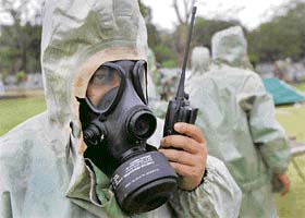 Soldiers listen to a wireless hand set during a mock exercise in the event of a chemical and biological terror attack situation in Kolkata