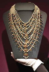 A natural pearl necklace once owned by Arab singer Umm Kulthum (1904-1975) is held by a member of staff at Christie's auction house in London on Friday.