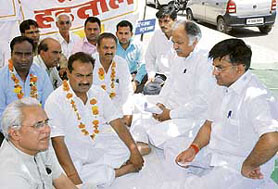 Working president of the HPCC Kuldeep Sharma (second from right) pacifies volunteers of the Pratima Raksha Samman Samiti who were protesting against the alleged seizure of photographs of martyrs in Karnal on Friday. 