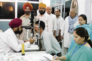 An eye specialist examines patients at a free medical camp held in Ludhiana on Friday. 